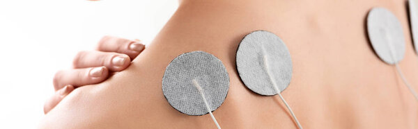 Cropped view of electrodes on female back isolated on white, panoramic shot