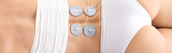 Top view of electrodes on back of woman during electrode treatment, panoramic shot