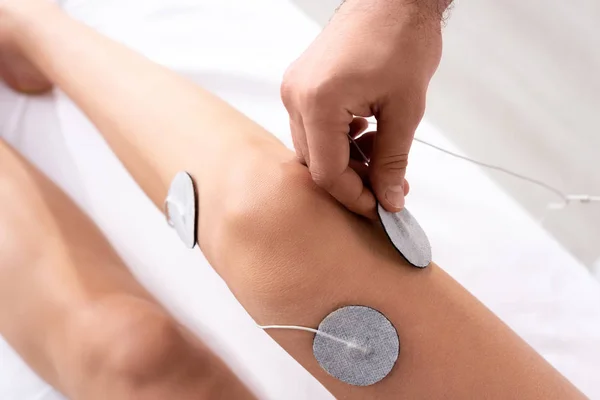 Bovenaanzicht Van Therapeut Instelling Elektroden Knie Van Patiënt Massage Bank — Stockfoto