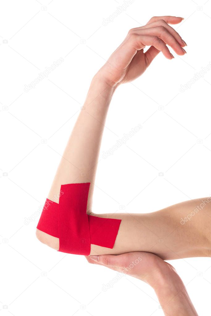 Cropped view of kinesiology tapes on cubit of woman isolated on white