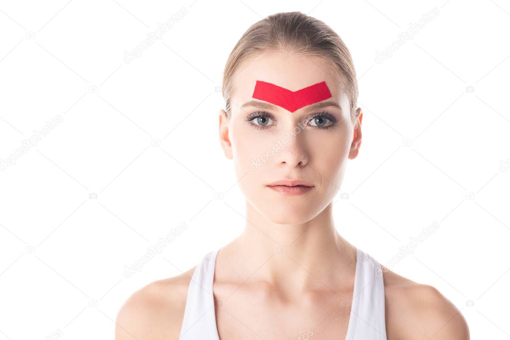 Attractive woman with kinesiology tapes on forehead looking at camera isolated on white