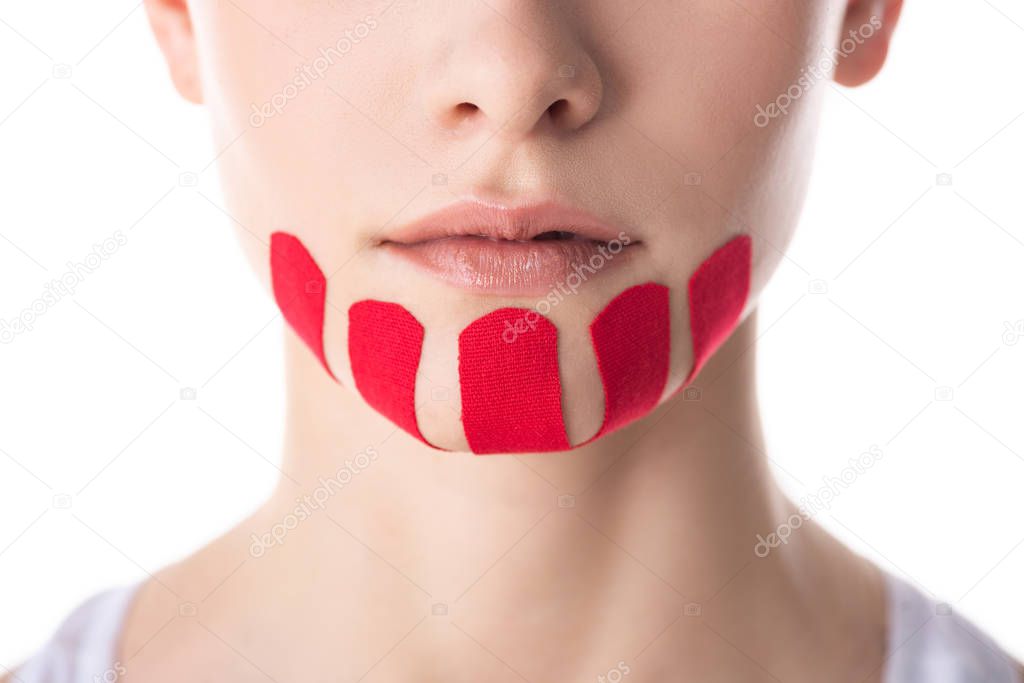 Cropped view of woman with kinesiology tapes on chin isolated on white