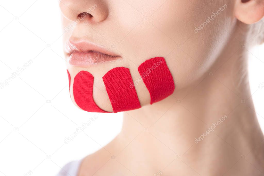 Cropped view of kinesiology tapes on chin of young woman isolated on white
