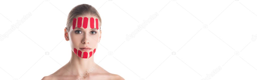 Beautiful woman with kinesiology tapes on forehead and chin looking at camera isolated on white, panoramic shot