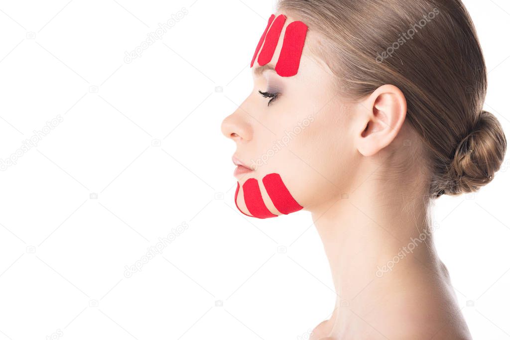 Side view of beautiful girl with kinesiology tapes on face isolated on white