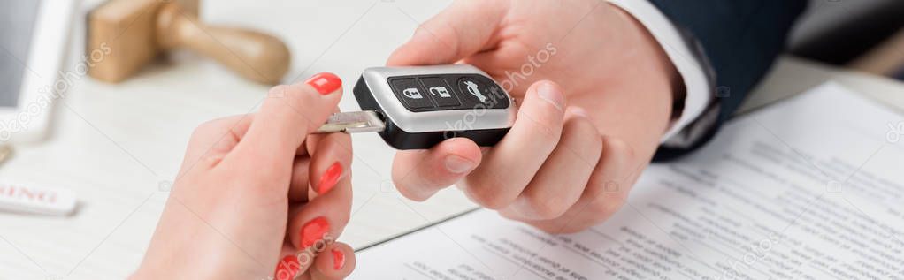 panoramic shot of realtor giving key to woman, leasing concept