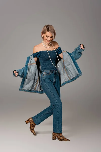 Aantrekkelijke Lachende Vrouw Spijkerjasje Jeans Grijze Achtergrond — Stockfoto