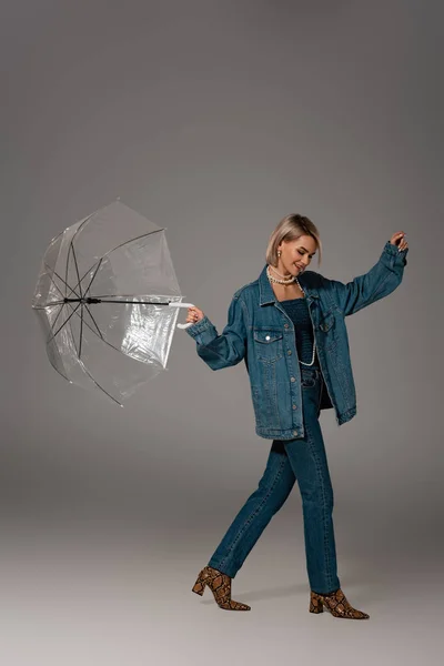 Leende Kvinna Jeans Jacka Och Jeans Håller Paraply Grå Bakgrund — Stockfoto