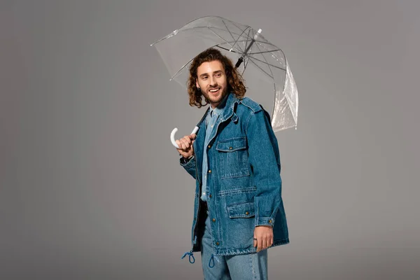 Hombre Guapo Sonriente Chaqueta Mezclilla Sosteniendo Paraguas Aislado Gris — Foto de Stock