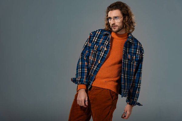 handsome man in shirt and trousers looking away isolated on grey