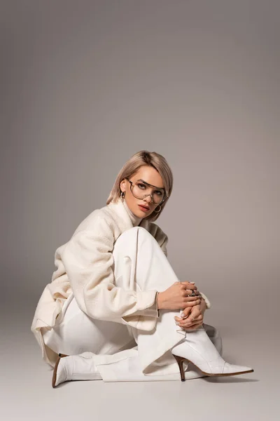 Mulher Atraente Casaco Branco Calças Sentadas Fundo Cinza — Fotografia de Stock
