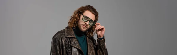 Panoramatický Záběr Pohledného Muže Kožené Bundě Dotýkající Brýlí Při Pohledu — Stock fotografie