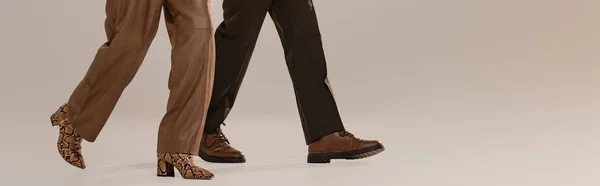 Tiro Panorâmico Mulher Homem Calças Calçado Andando Sobre Fundo Cinza — Fotografia de Stock