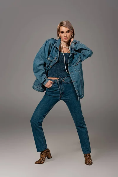 Aantrekkelijke Vrouw Spijkerjasje Jeans Kijkend Naar Camera Grijze Achtergrond — Stockfoto