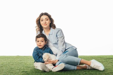 smiling mother and son with Havanese puppy isolated on white