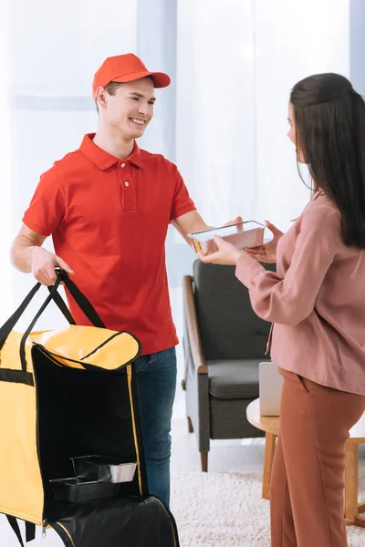 Lächelnder Auslieferer Mit Thermosack Gibt Frau Hause Lebensmittelbehälter — Stockfoto