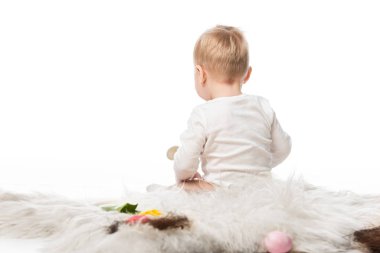 Back view of cute kid sitting on fur isolated on white clipart
