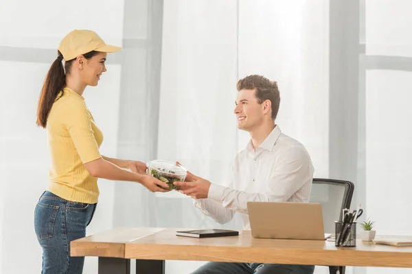 Seitenansicht Eines Lächelnden Kuriers Der Einem Geschäftsmann Tisch Container Mit — Stockfoto