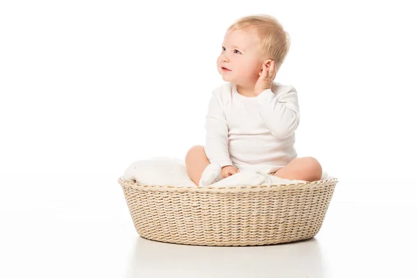 Dítě Dotýká Ucha Odvrací Pohled Sedí Přikrývce Košíku Bílém Pozadí — Stock fotografie