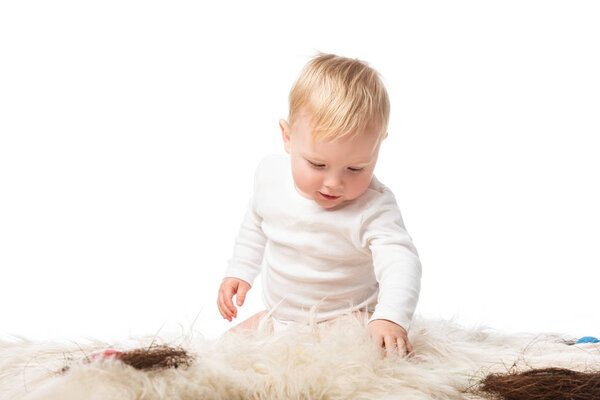 Ребенок смотрит вниз, сидит на мехе с гнездами изолированы на белом
 