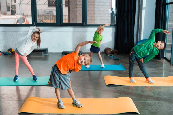 Crianças Multiculturais Aquecendo Juntas Tapetes Fitness Ginásio — Fotografia de Stock