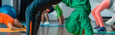 Fitness paspasları ve panoramik çekim üzerine jimnastik köprüsü yapan çocukların seçici odak noktası
