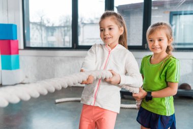 Spor merkezinde çekiştirmece oynayan mutlu çocukların seçici odağı