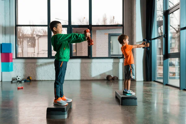 Side View Multicultural Kids Outstretched Hands Holding Dumbbells Standing Step — Stock Photo, Image