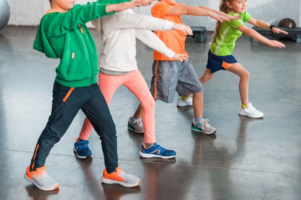 Vista Recortada Niños Con Las Manos Extendidas Haciendo Embestidas Gimnasio — Foto de Stock