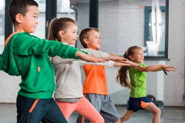 Selective Focus Multiethnic Children Outstretched Hands Doing Lunges Gym — Stock Photo, Image
