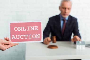 Online müzayede mektupları ve tokmağı olan açık arttırmacı kadın görüntüsü. 