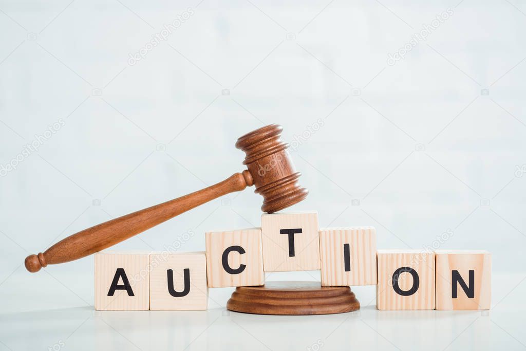 gavel and wooden cubes with auction lettering on white background 