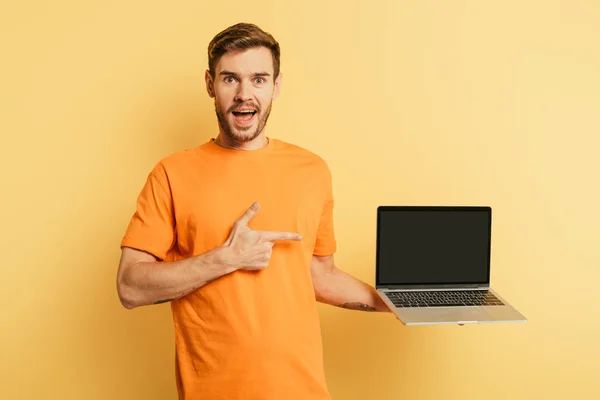 Joven Excitado Apuntando Con Dedo Computadora Portátil Con Pantalla Blanco — Foto de Stock