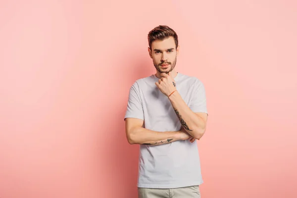 Thoughtful Young Man Touching Chin While Looking Camera Pink Background — Stock Photo, Image