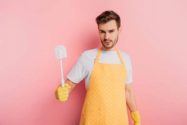 Serious Young Man Apron Rubber Gloves Holding Toilet Brush Pink — Stock Photo, Image