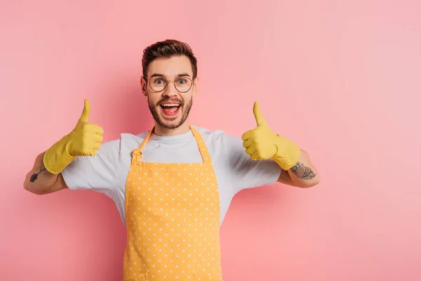 Serieuze Jongeman Schort Rubber Handschoenen Tonen Duimen Omhoog Roze Achtergrond — Stockfoto