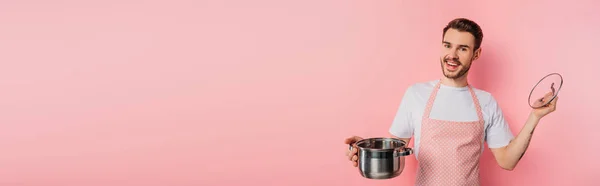 Panoramic Shot Happy Young Man Apron Opening Saucepan Pink Background — Stock Photo, Image