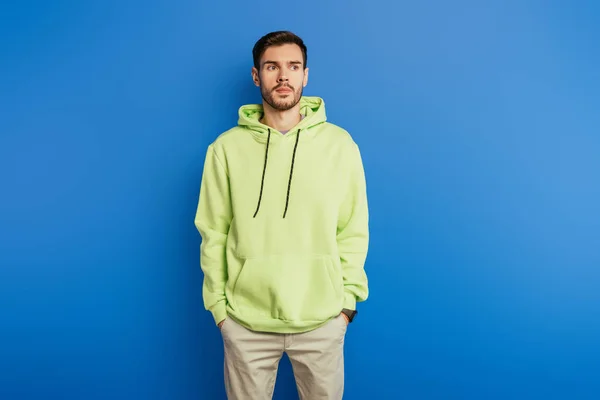 Handsome Confident Young Man Standing Hands Pockets Looking Away Blue — Stock Photo, Image