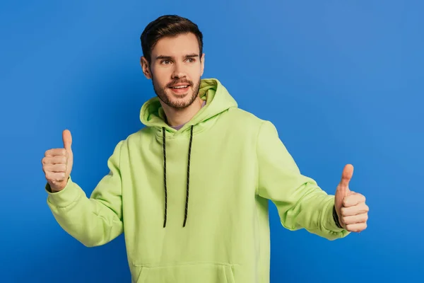 Excited Young Man Showing Thumbs While Looking Away Isolated Blue — Stock Photo, Image