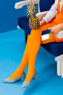 Eski moda elbiseli Afro-Amerikan 'ın mavi arka planda uçak bileti olan ananas ve pasaportu. 