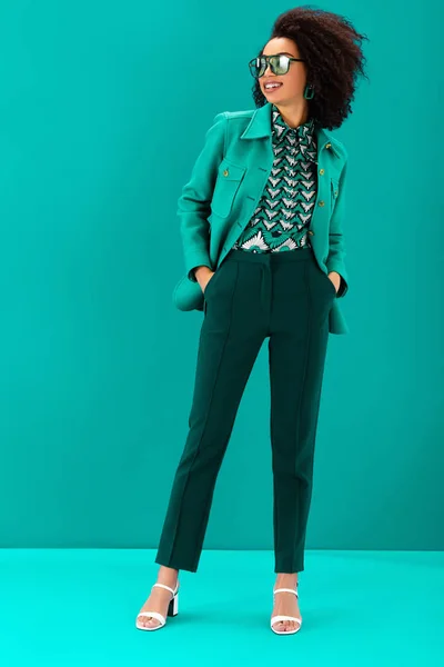 Smiling African American Woman Stylish Jacket Hands Pockets Turquoise Background — Stock Photo, Image