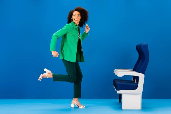 Smiling African American Woman Running Seats Blue Background — Stock Photo, Image