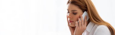 Panoramic shot of businesswoman talking on smartphone on white background