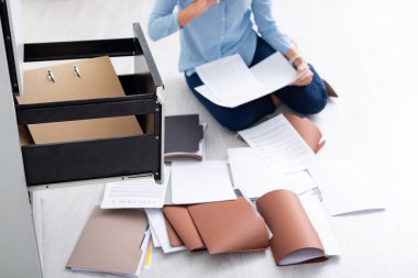 Cropped view of businesswoman with contract and documents near open cabinet driver on floor clipart