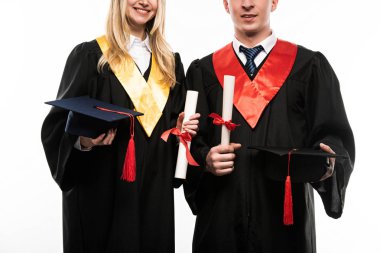 Mezuniyet kepleri ve diplomaları olan öğrencilerin beyazlar üzerinde izole edilmiş ön görünüşü
