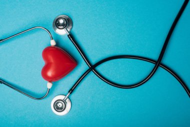 Top view of decorative red heart and black stethoscope on blue background, world health day concept clipart