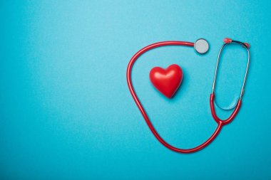 Top view of decorative heart and red stethoscope on blue background, world health day concept clipart