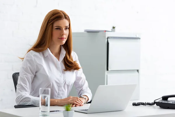 Empresária Atraente Olhando Para Mesa Com Laptop Telefone — Fotografia de Stock