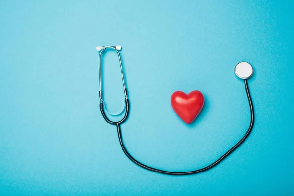 Draufsicht Auf Dekoratives Rotes Herz Und Stethoskop Auf Blauem Hintergrund — Stockfoto