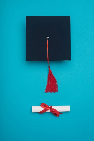 Mezuniyet Şapkasının Üst Görüntüsü Kırmızı Püskül Mavi Arka Planda Diploma — Stok fotoğraf